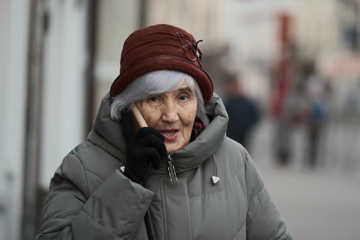 An elderly woman talking warmly on the phone
